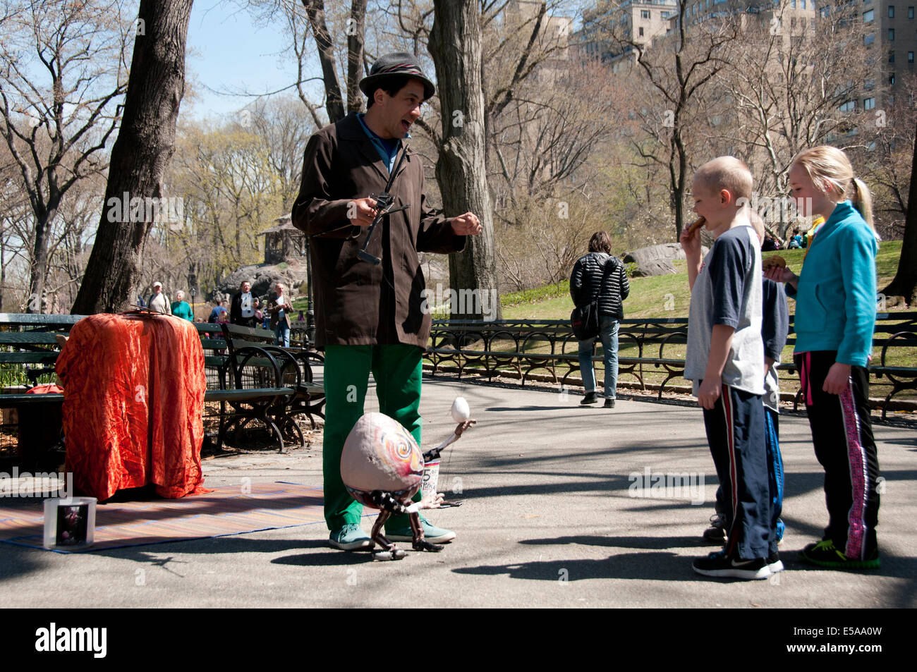 Street entertainer showing puppet to children in Central Park Stock