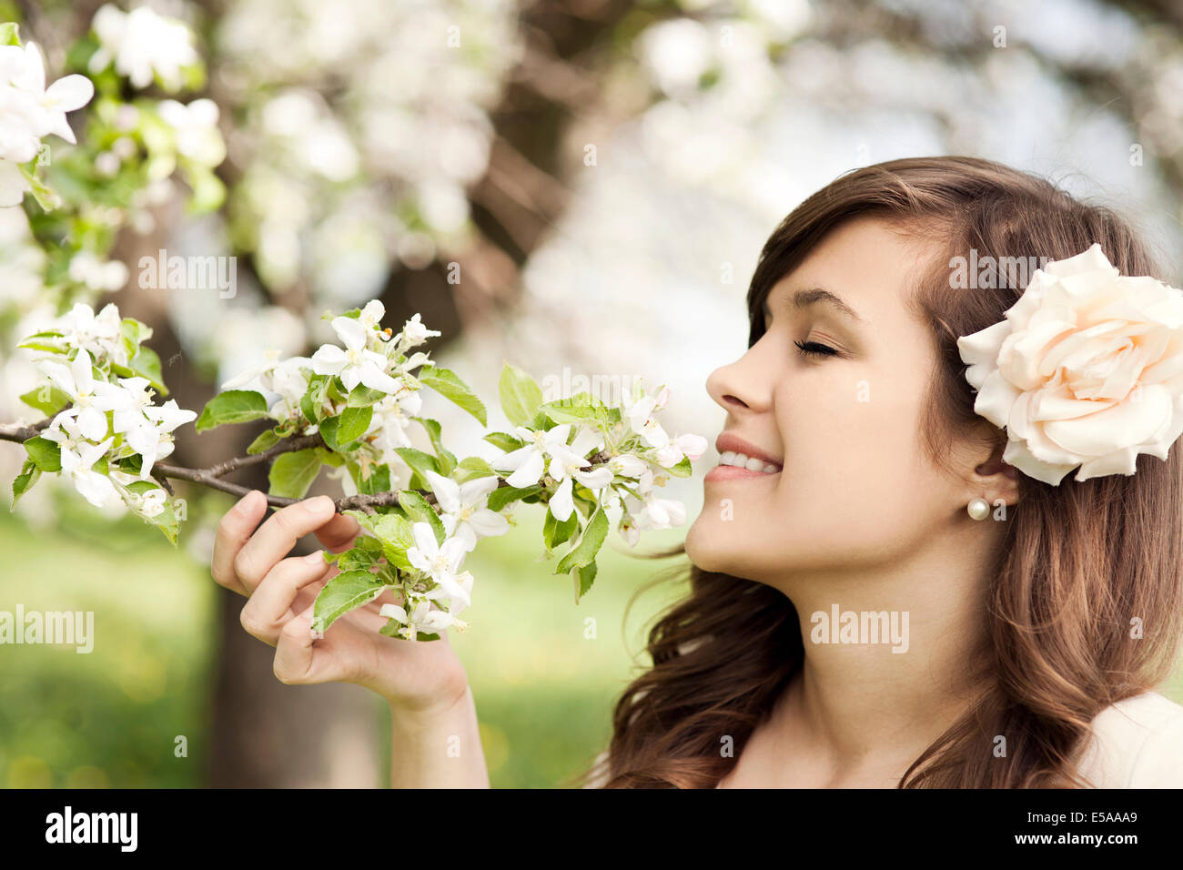 Happy young woman enjoying the fragrance of flowers. Debica, Poland. Stock Photo