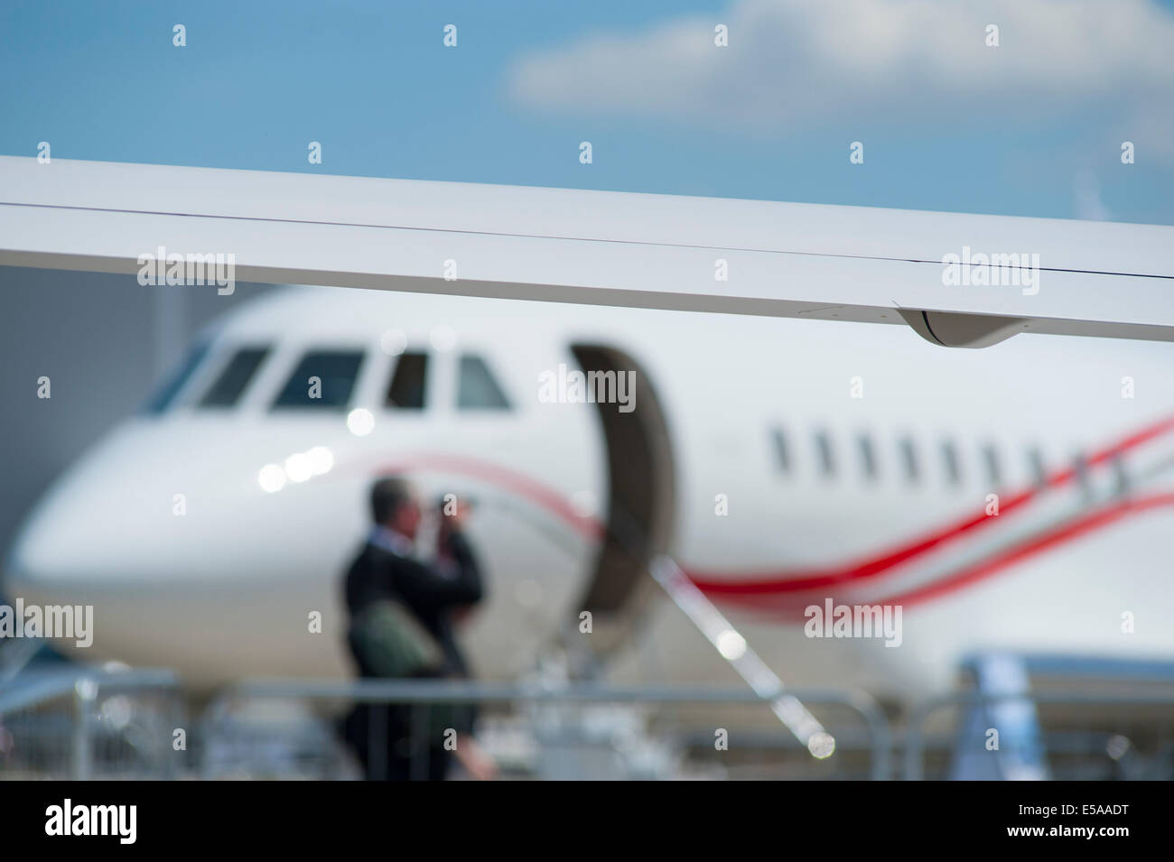 Aircraft wing with visitor photographing VIP jet, Farnborough International Airshow 2014 Stock Photo