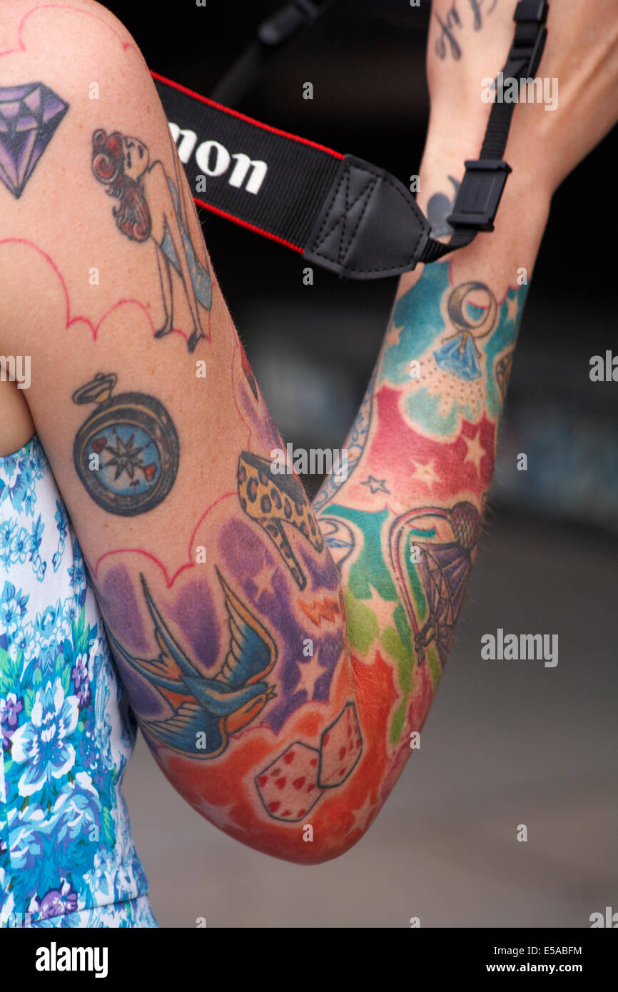 coloured tattoos covering womans arm Stock Photo