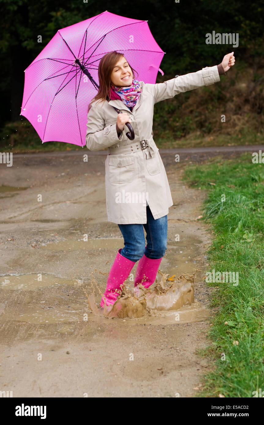 Young woman with rubber boots have fun, rainy day, Debica, Poland. Stock Photo