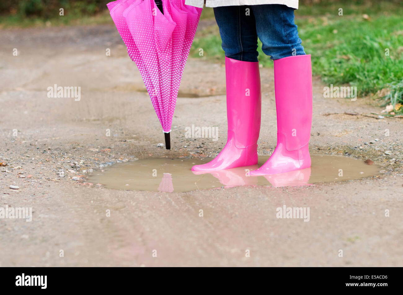 Young woman standing in puddle, Debica, Poland. Stock Photo