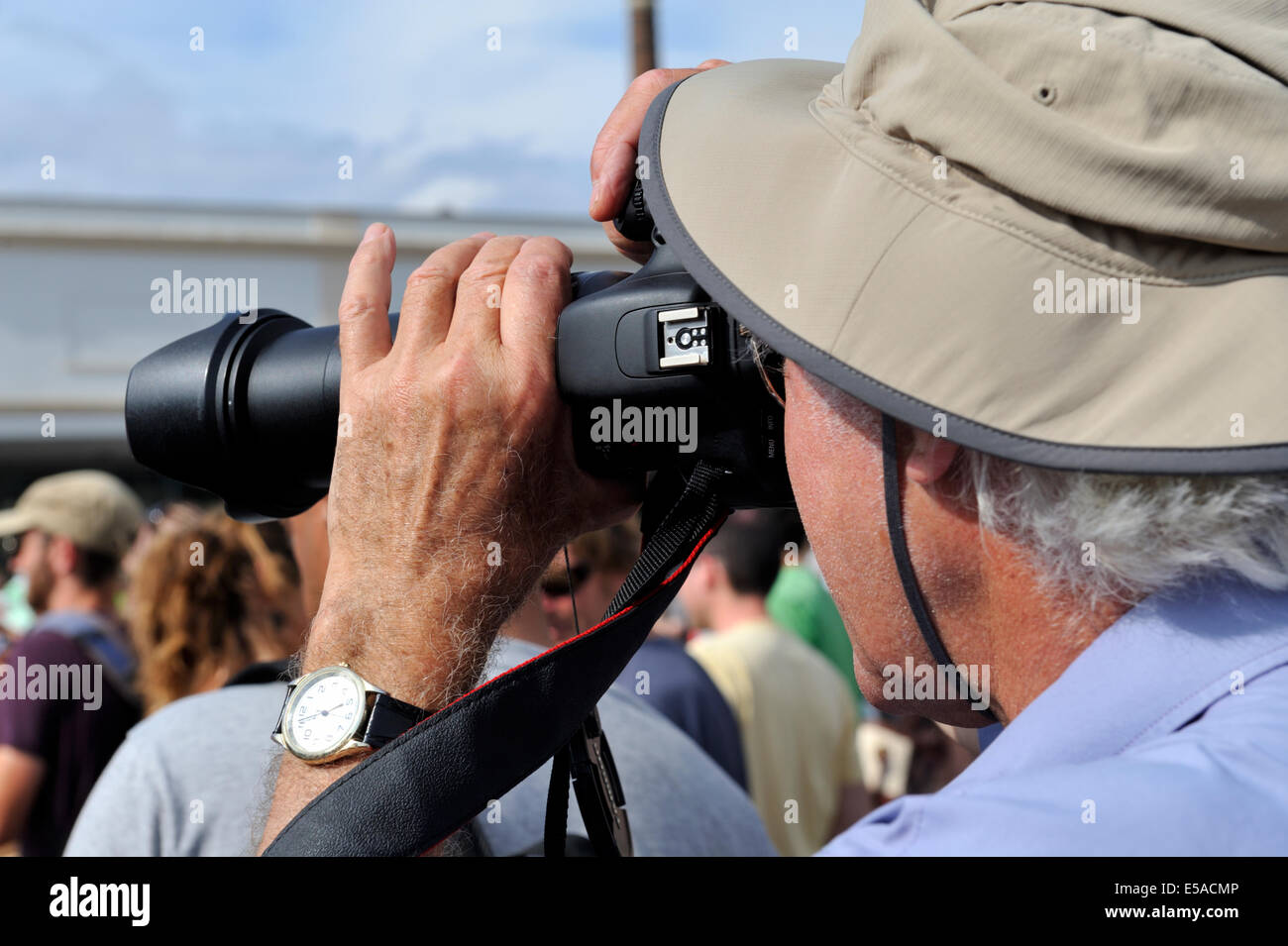 Man holding a camera taking a photograph at a festival] Stock Photo