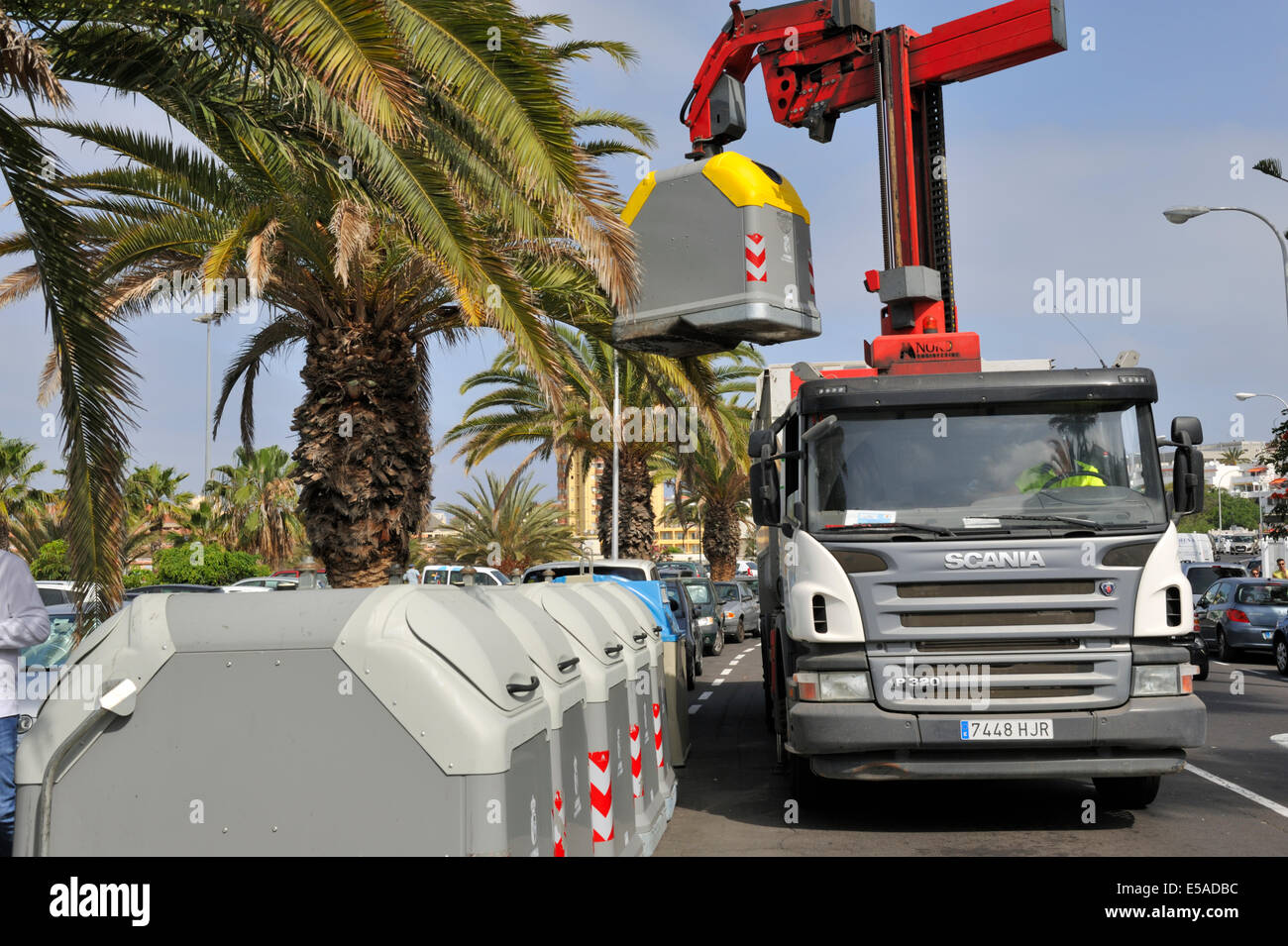 Automated handling system for waste and recycling bins. Driver latches onto bin, lifts it, swings it over his lorry Stock Photo