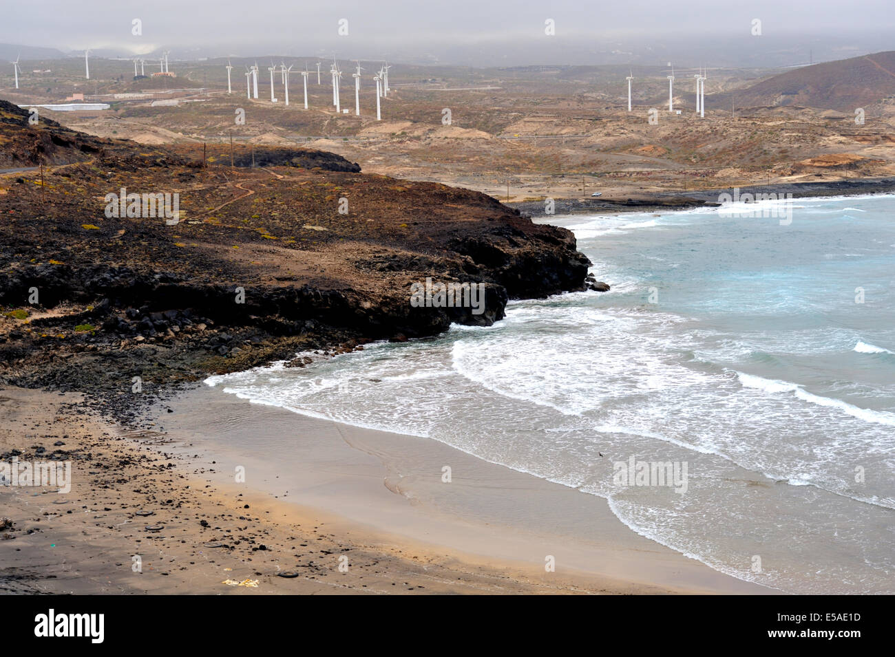 Low tide at Poris de Abona beach with wind turbines in background, Tenerife Stock Photo