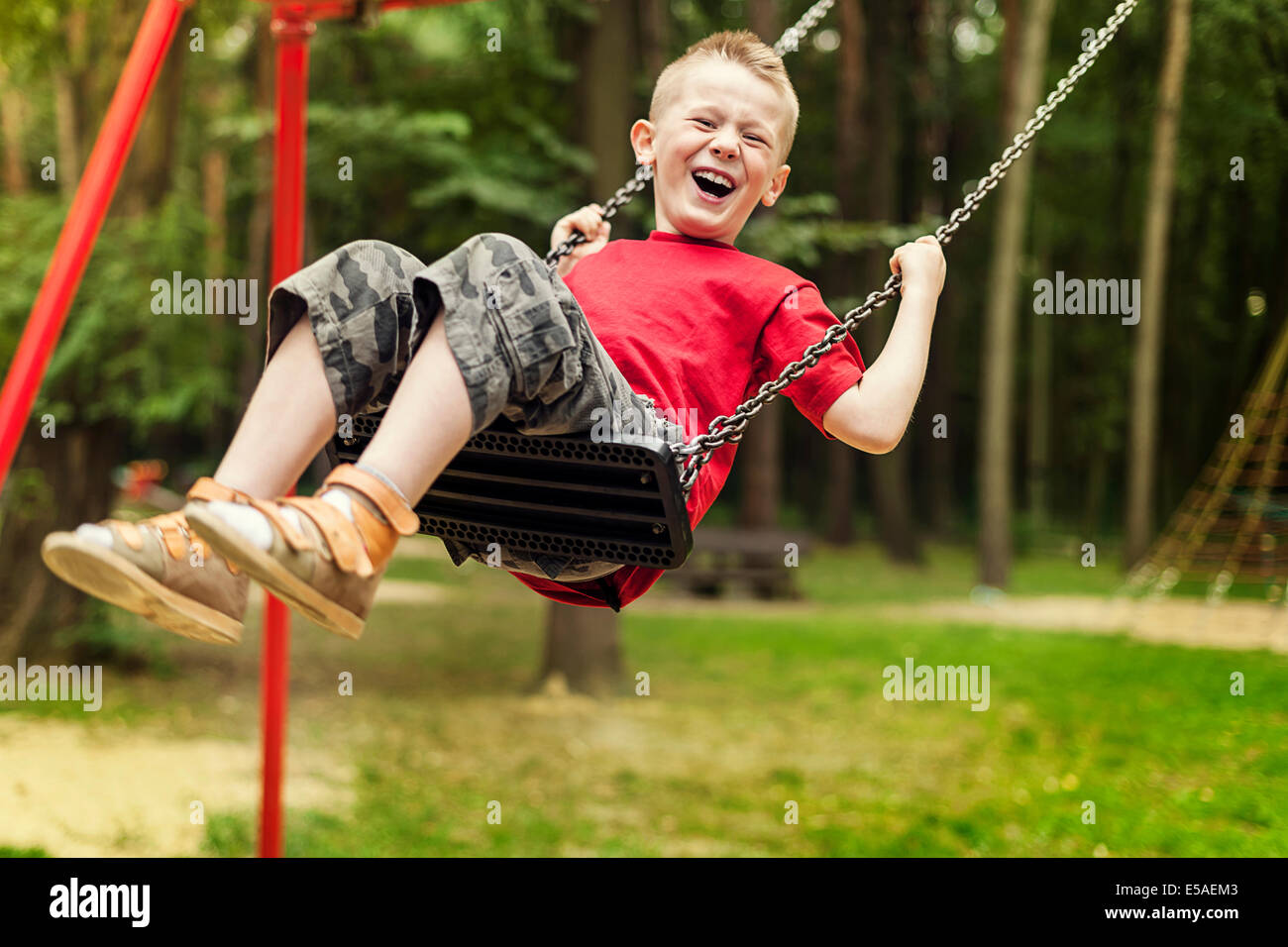 Little boy swinging, Debica, Poland Stock Photo Alamy