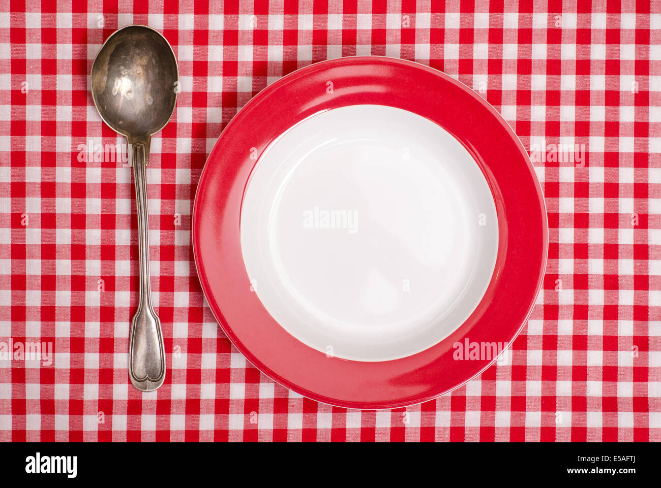 Red checked table cloth with plate and silver spoon Stock Photo - Alamy