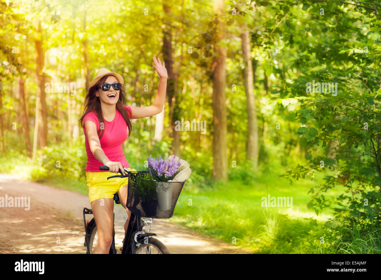 Beautiful woman waving to someone during cycling, Debica, Poland. Stock Photo