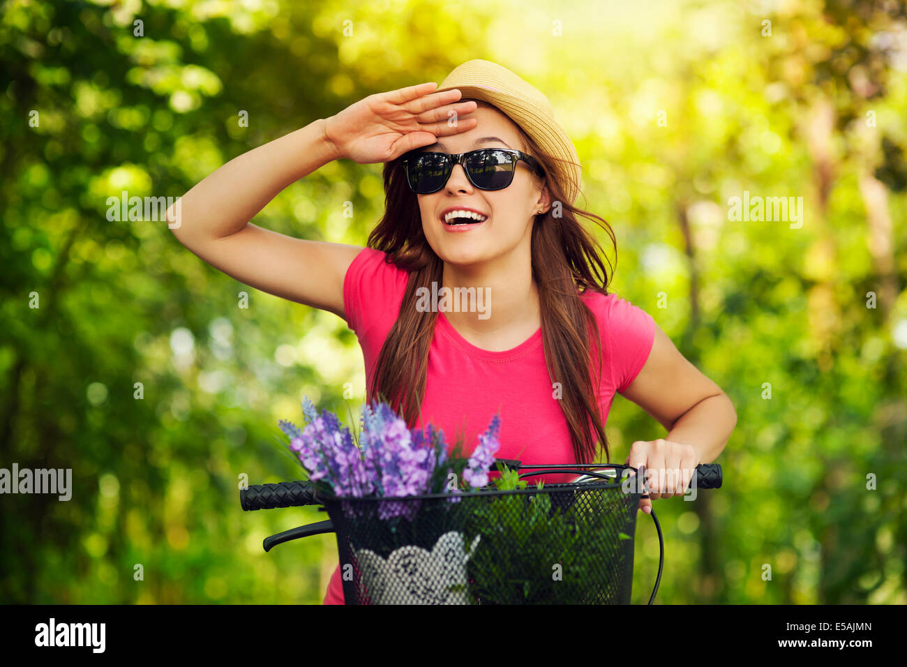 Happy woman with bike watching something, Debica, Poland Stock Photo