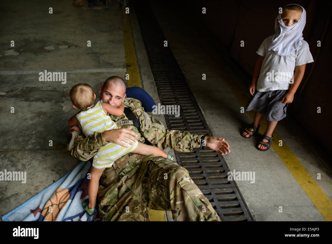 July 24, 2014 - Fort Bragg, NC, USA - July 24, 2014 - Fort Bragg, N.C., USA - Warrant Officer Casey Matullo plays with his two sons, Gabriel, 2, and Michael, Thursday, July 24, 2014, on Fort Bragg, N.C., before he and his fellow soldiers from Company C, 3rd General Support Aviation Battalion, 82nd Combat Aviation Brigade deploy to Afghanistan for nine months. (Credit Image: © Andrew Craft/ZUMA Wire/ZUMAPRESS.com) Stock Photo