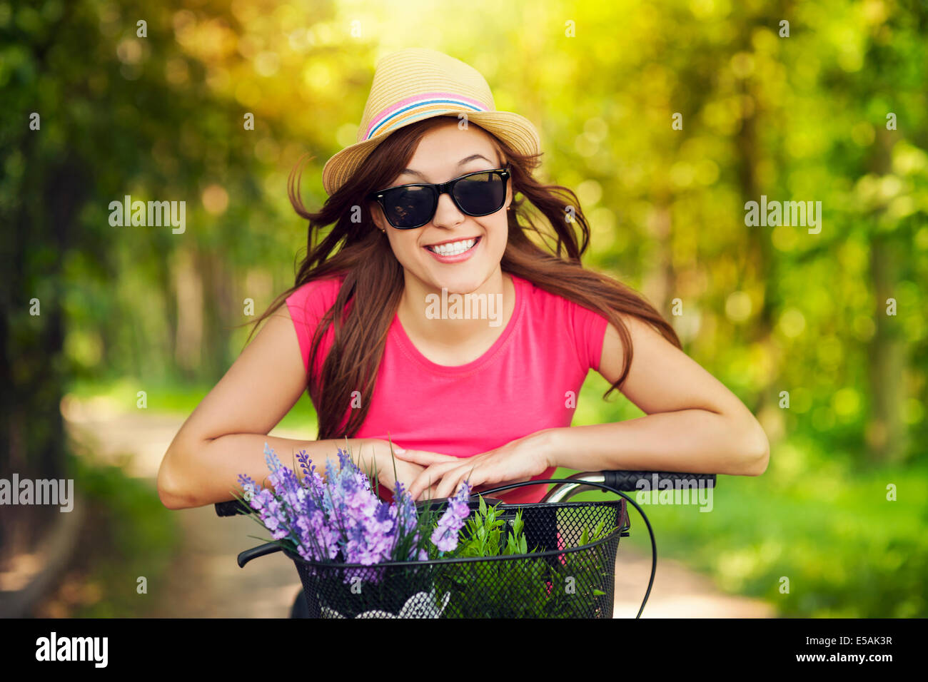 Portrait of smiling woman riding bicycle in park, Debica, Poland. Stock Photo