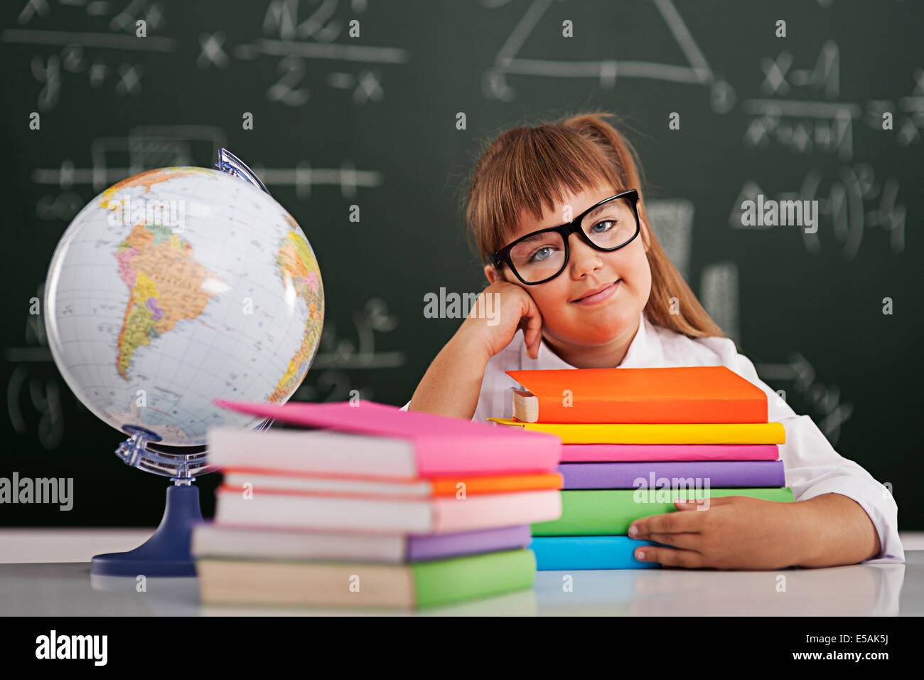 Smiling little girl with stack of books, Debica, Poland Stock Photo - Alamy