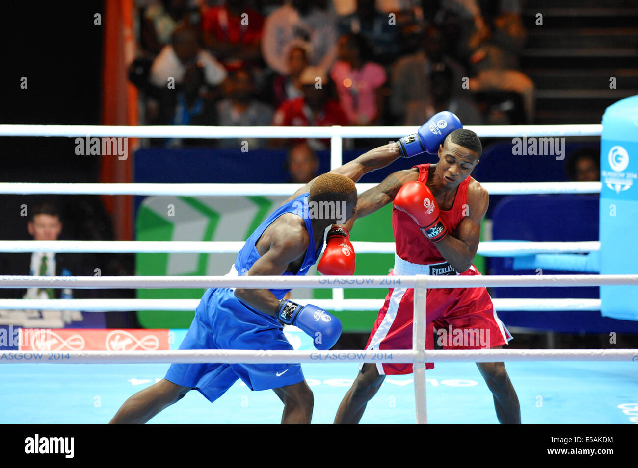 Merven Clair (MRI, red) and Rayton Okwiri (KEN, blue) boxing during the preliminary matches of the boxing competitions at the XX Commonwealth Games, Glasgow. The match was won by Rayton Okwiri. Stock Photo