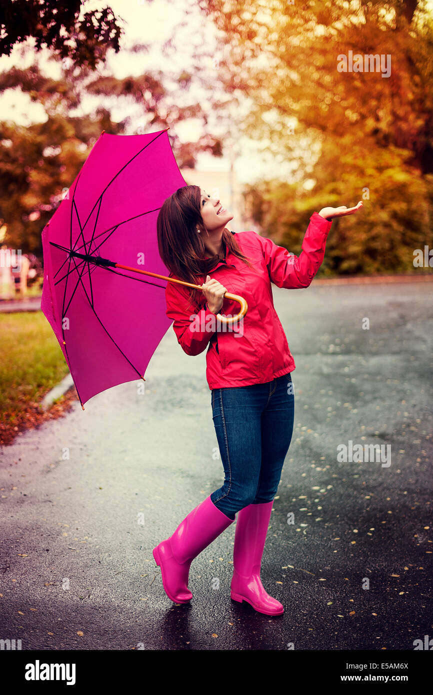 Happy woman with umbrella checking for rain in a park Debica, Poland Stock Photo
