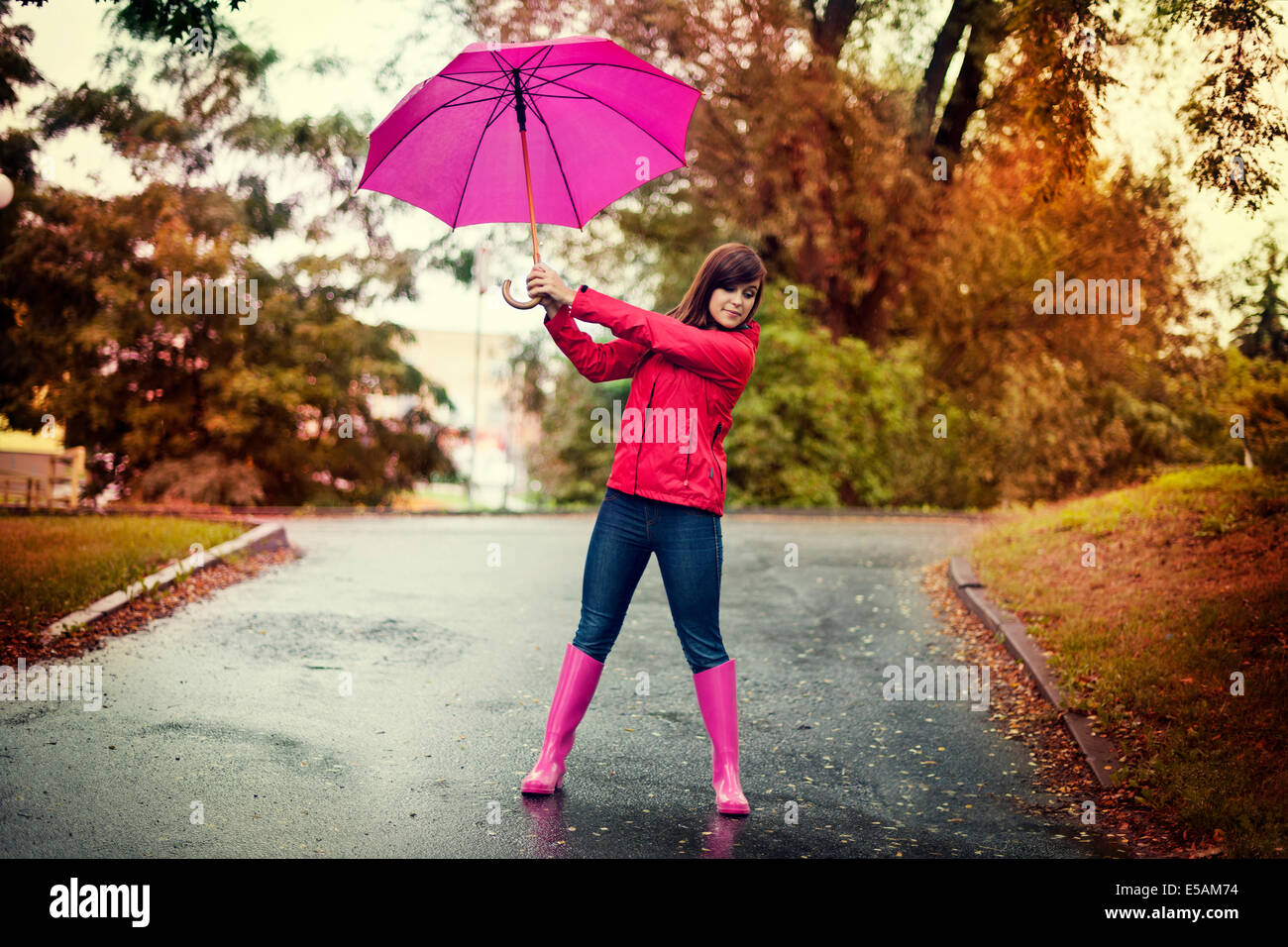 Young woman holding pink umbrella in a park, Debica, Poland Stock Photo