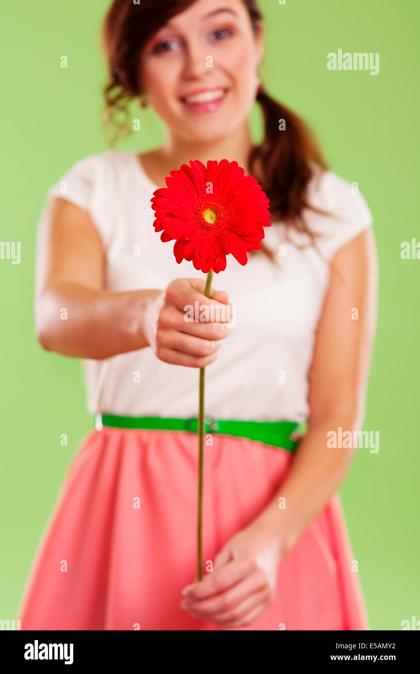 Young woman showing a red gerbera Debica, Poland Stock Photo