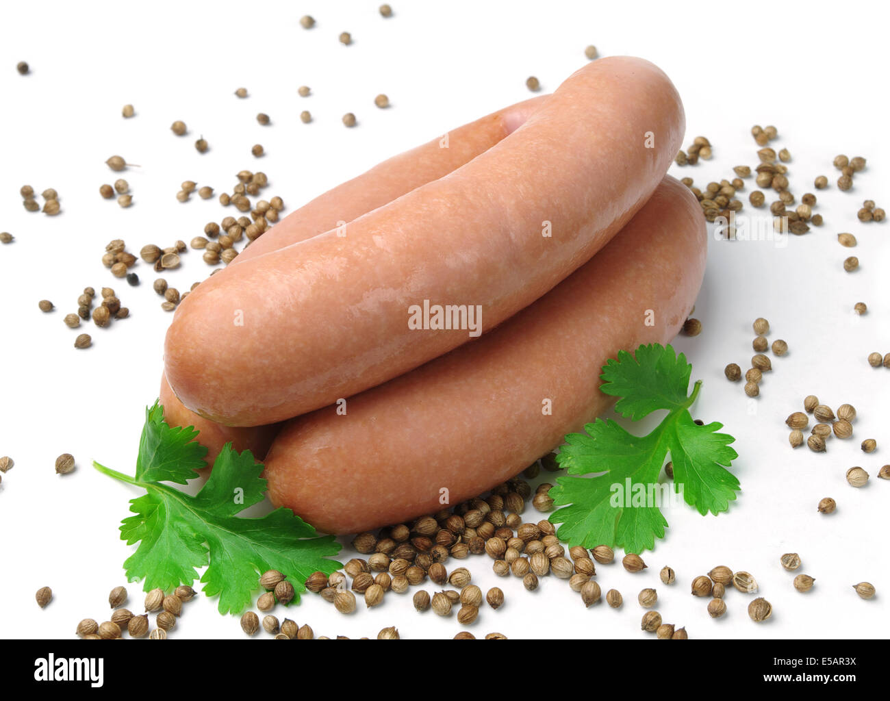 Sausages and grains of coriander Stock Photo