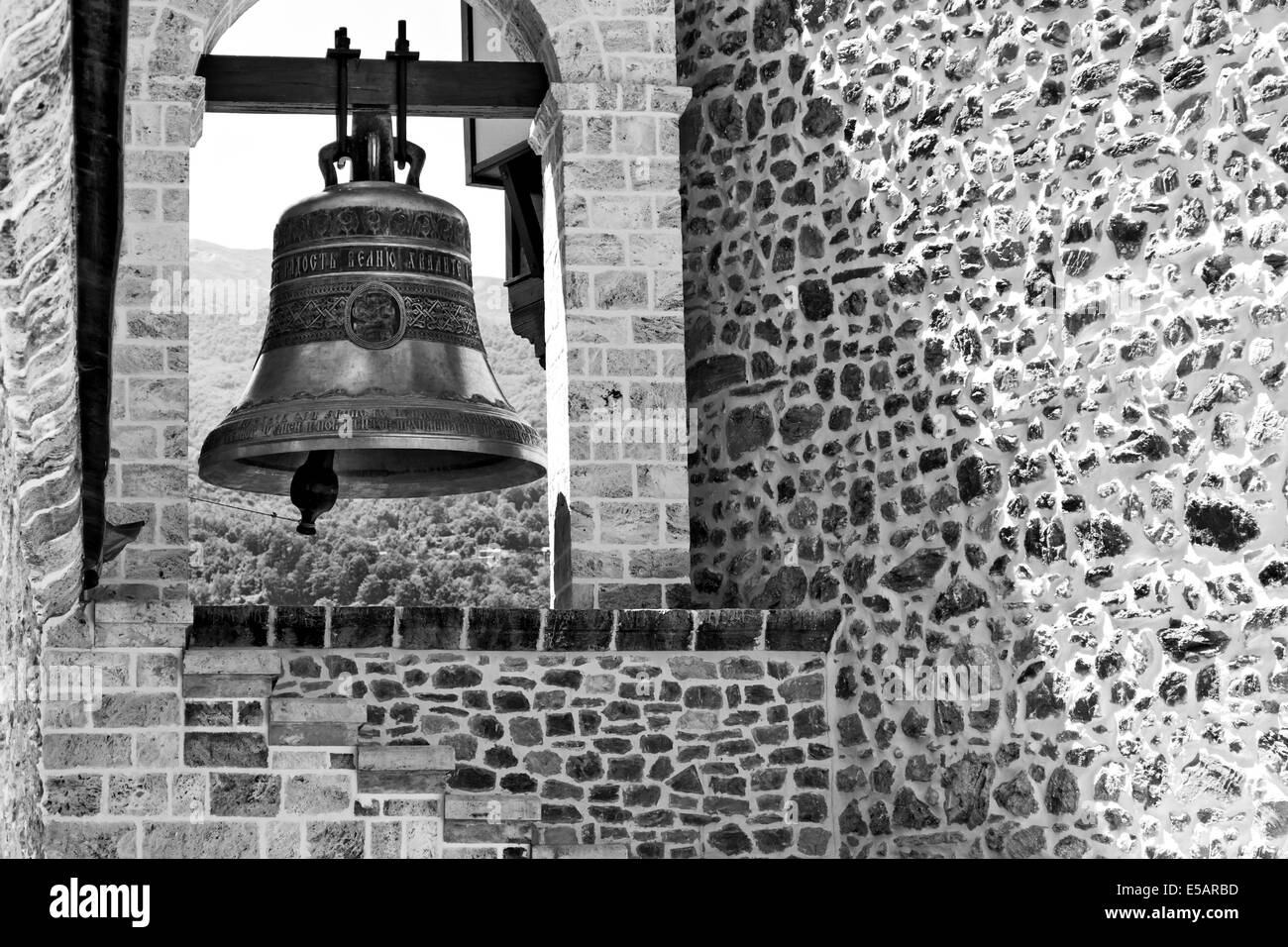 Church bell and rustic stone wall BW Stock Photo