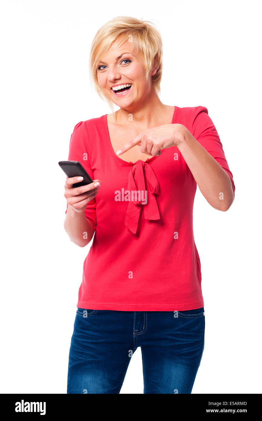Laughing woman pointing on mobile phone Debica, Poland Stock Photo