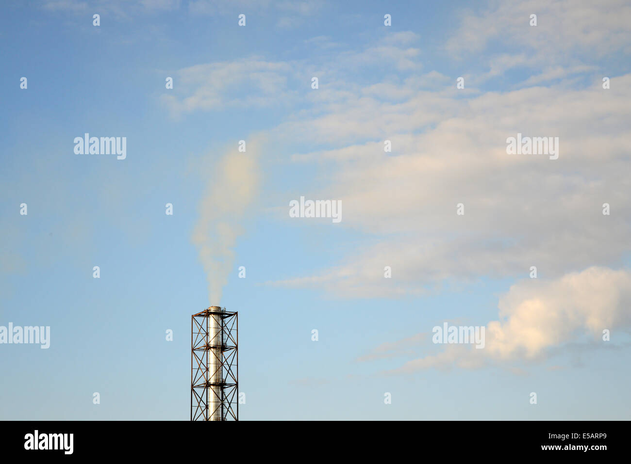 smoke from a chimney on a blue sky Stock Photo