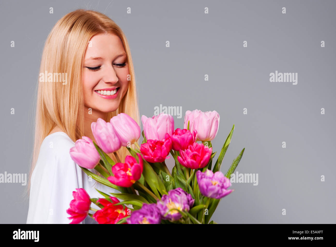 Happy woman holding pink and purple tulips Debica, Poland Stock Photo