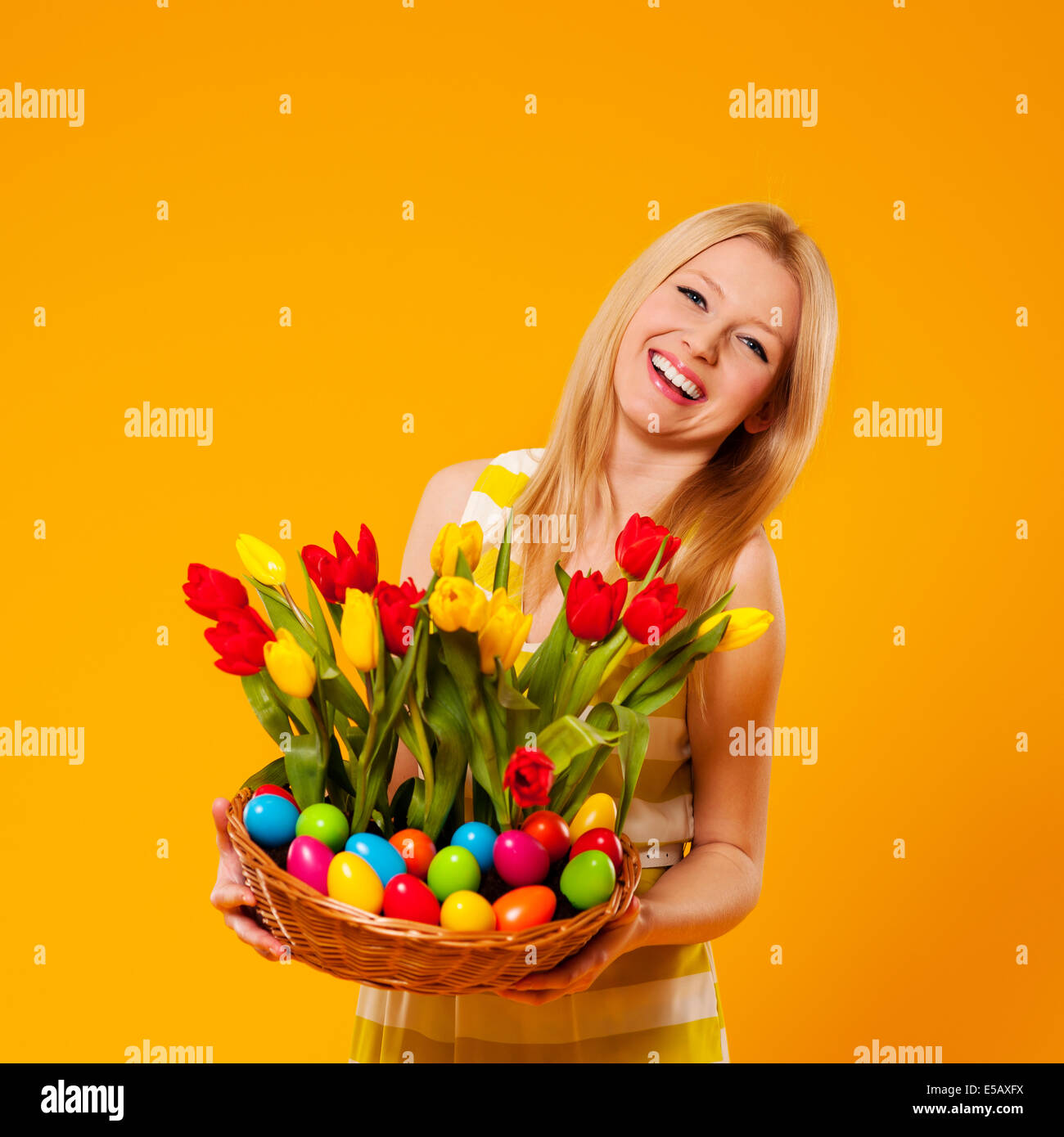 Happy woman holding basket with spring flower and Easter eggs Debica, Poland Stock Photo