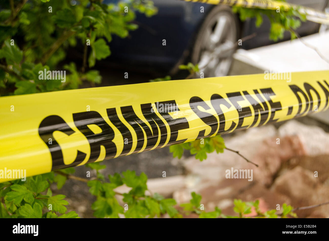 Crime scene tape surrounding an incident - details of scene out of focus. Stock Photo