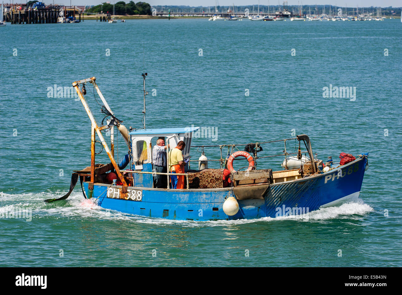 Fishing boat entering harbour Stock Photo - Alamy