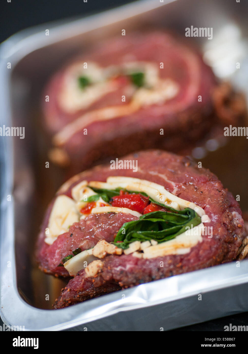 Steaks wrapped with cheese and spinach in a cooking pan Stock Photo