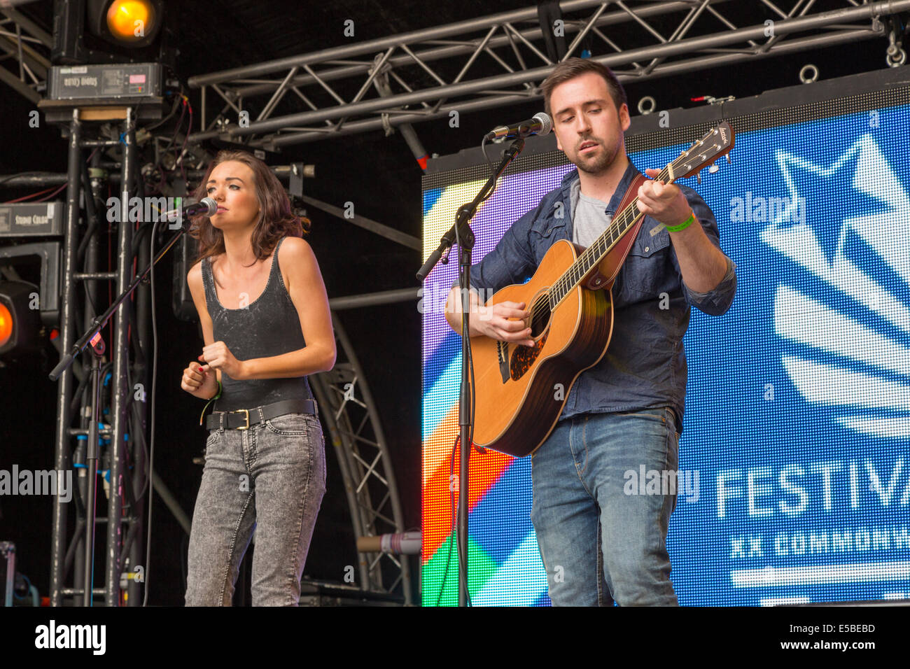 Man and woman perform on stage, singing with acoustic guitar. West End Festival, Glasgow, Scotland, UK, 2014 Stock Photo