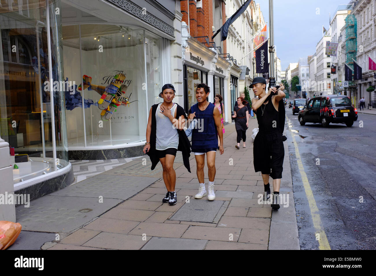 three happy gay Asian men walking on Bond Street, London Stock Photo
