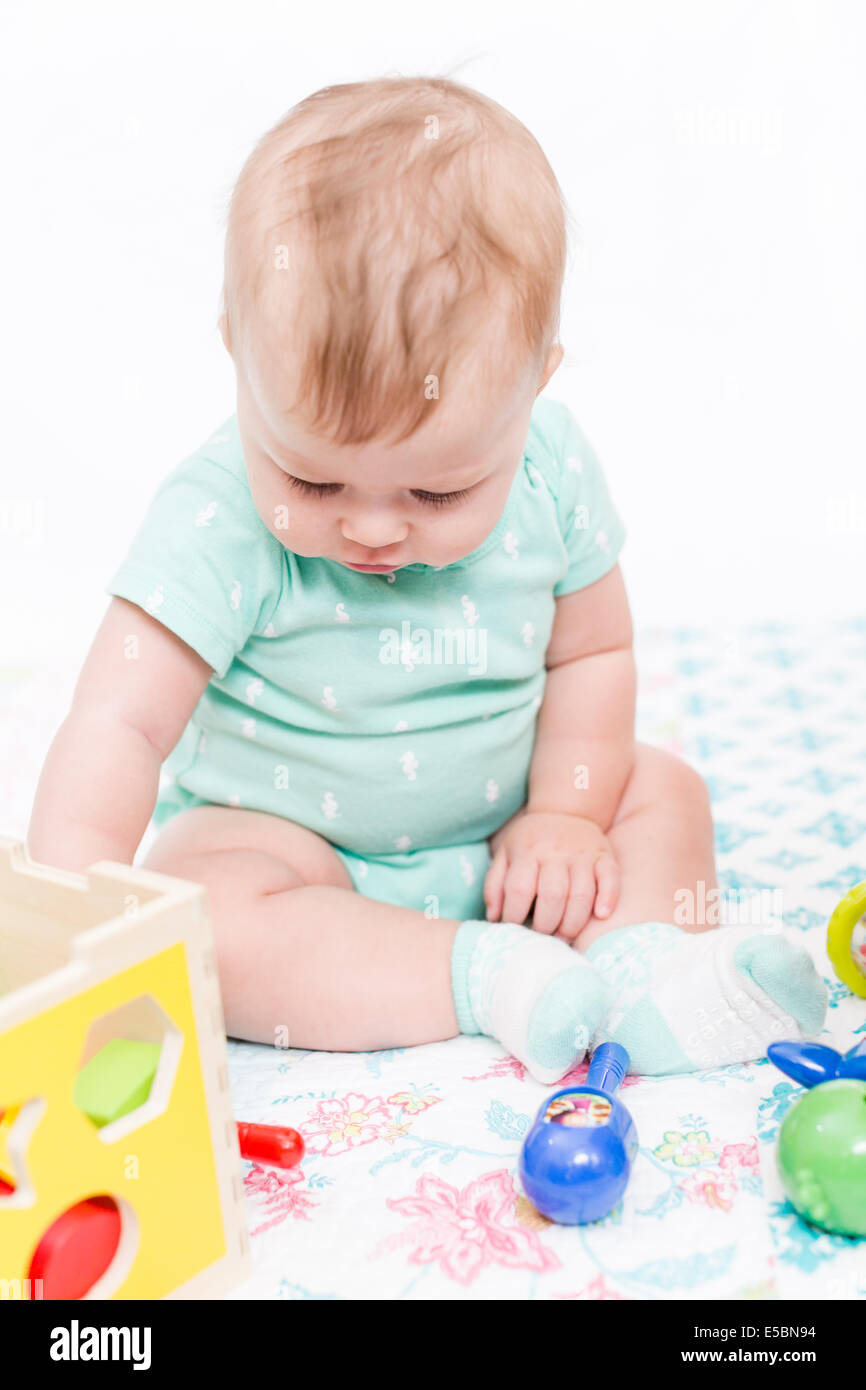 Cute baby girl playing with her toys on a blanket Stock Photo - Alamy