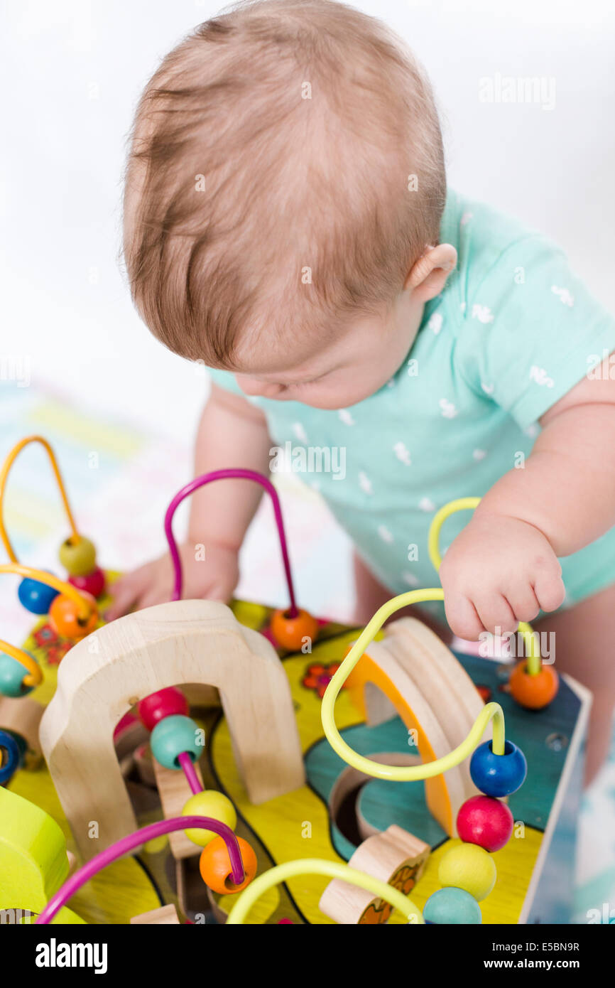 Cute baby girl playing with her toys on a blanket Stock Photo - Alamy