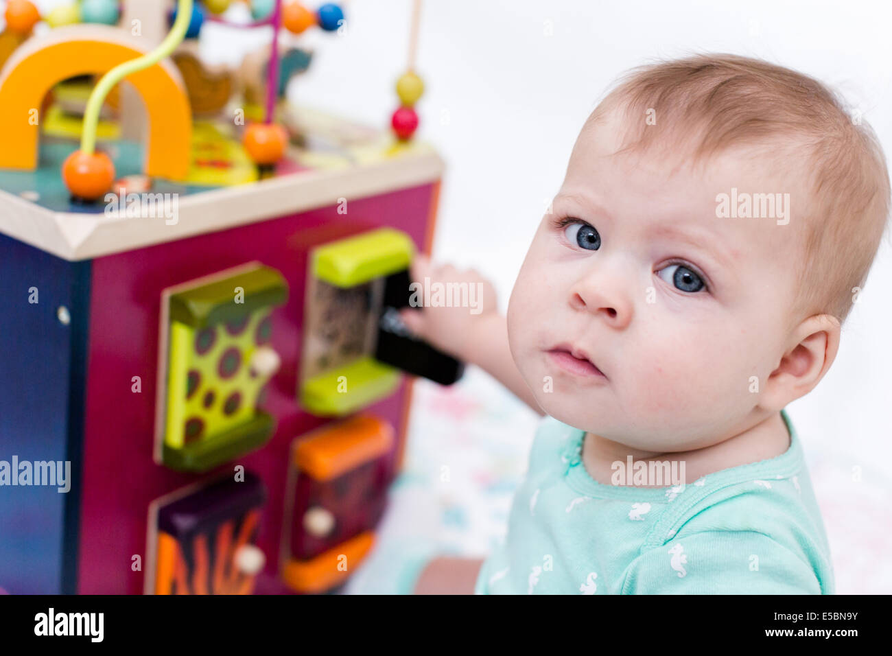 Cute baby girl playing with her toys on a blanket Stock Photo - Alamy