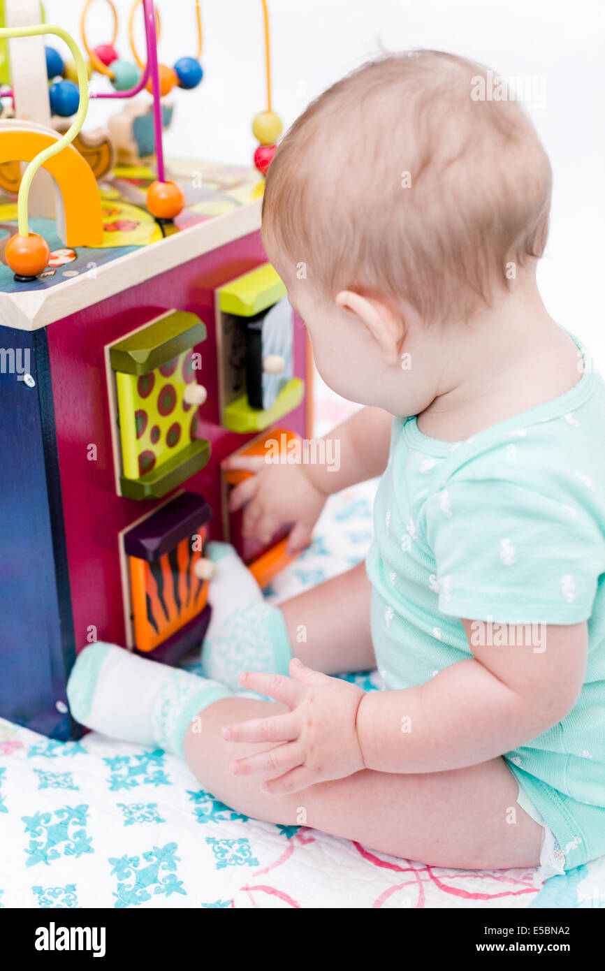 Cute baby girl playing with her toys on a blanket Stock Photo - Alamy