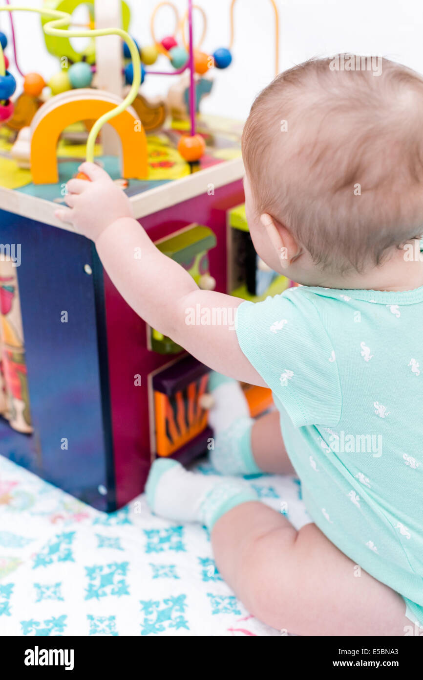 Cute baby girl playing with her toys on a blanket Stock Photo - Alamy