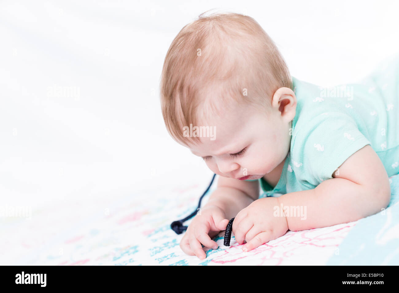 Cute baby girl playing with her toys on a blanket Stock Photo - Alamy