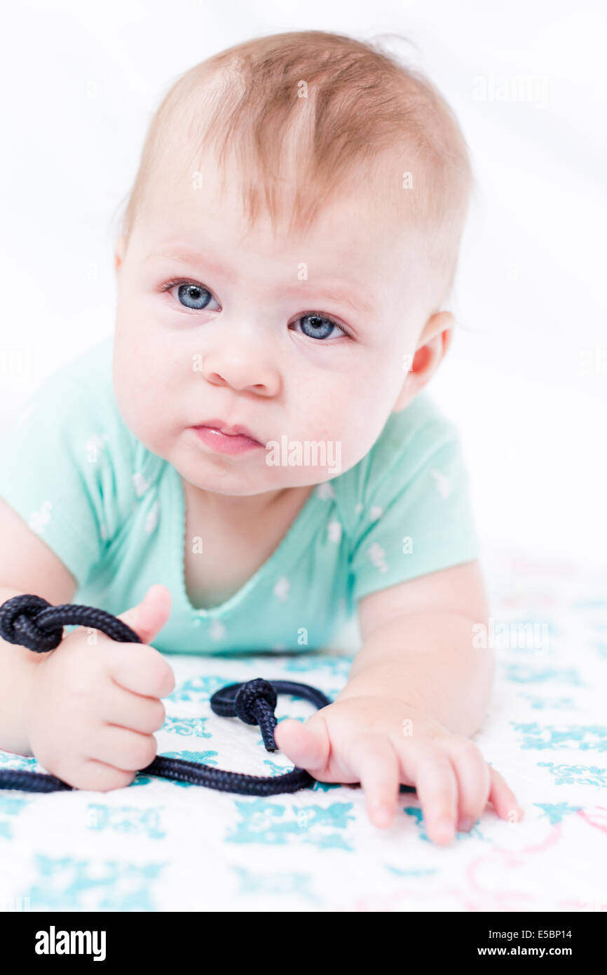 Cute baby girl playing with her toys on a blanket Stock Photo - Alamy