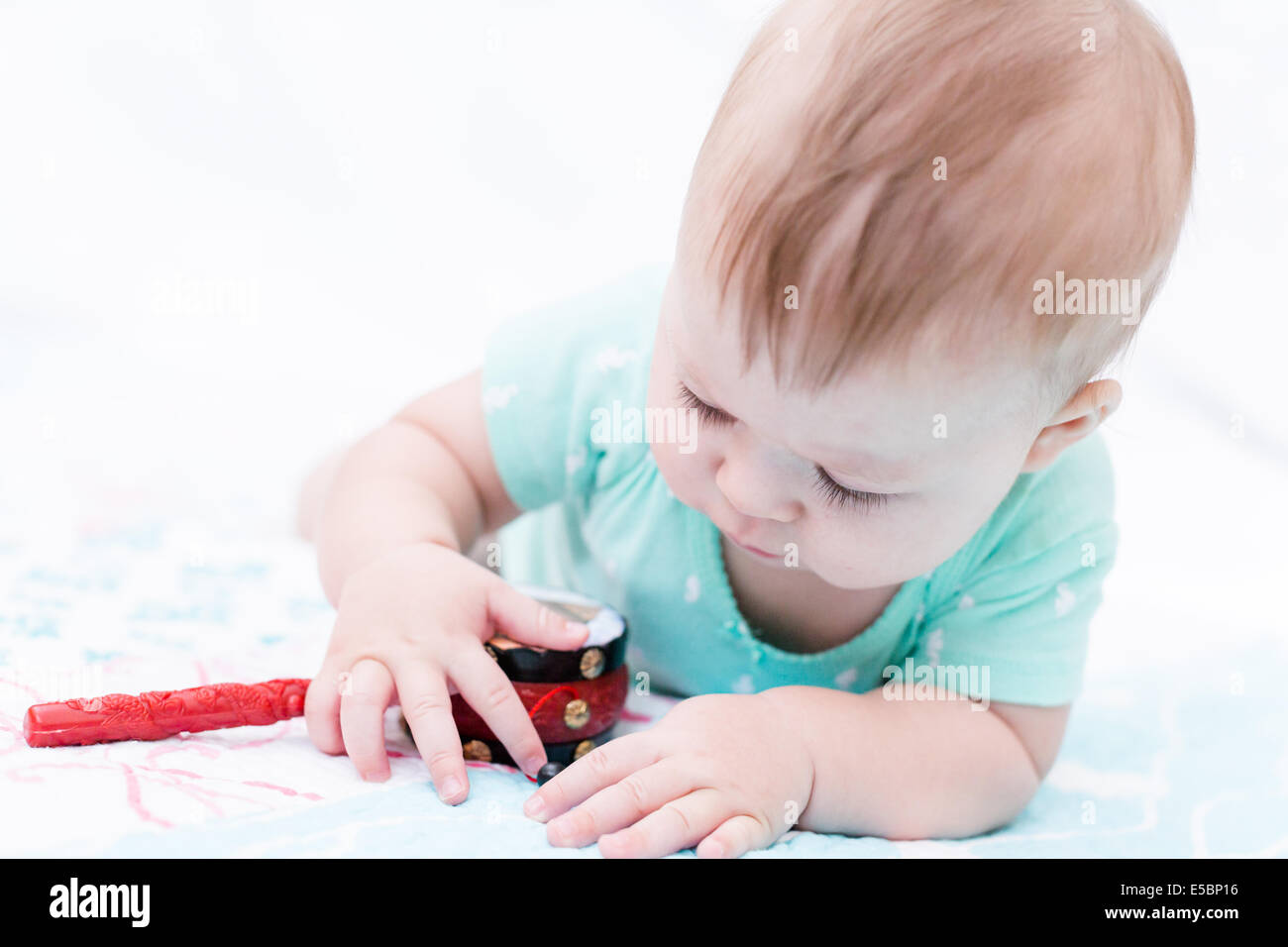 Cute baby girl playing with her toys on a blanket Stock Photo - Alamy
