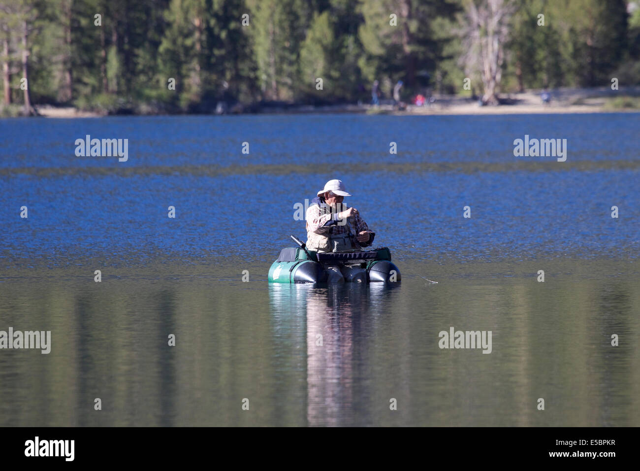 Fisherman on rock creek lake fishing from a float tube in the Eastern Sierra Nevada mountains California Stock Photo
