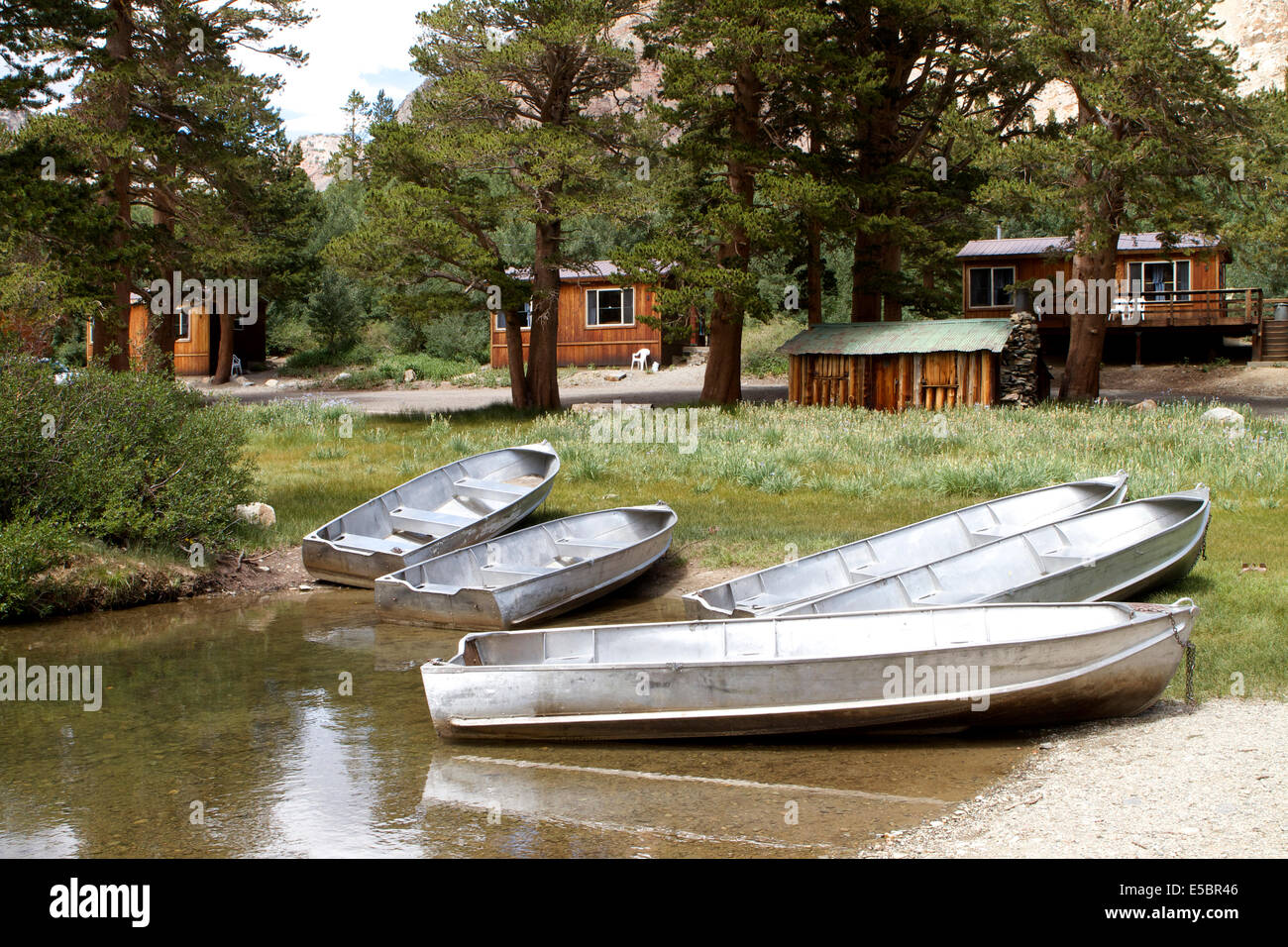 Aluminum Boats On A Lake Bank With Guest Cabins In The Background