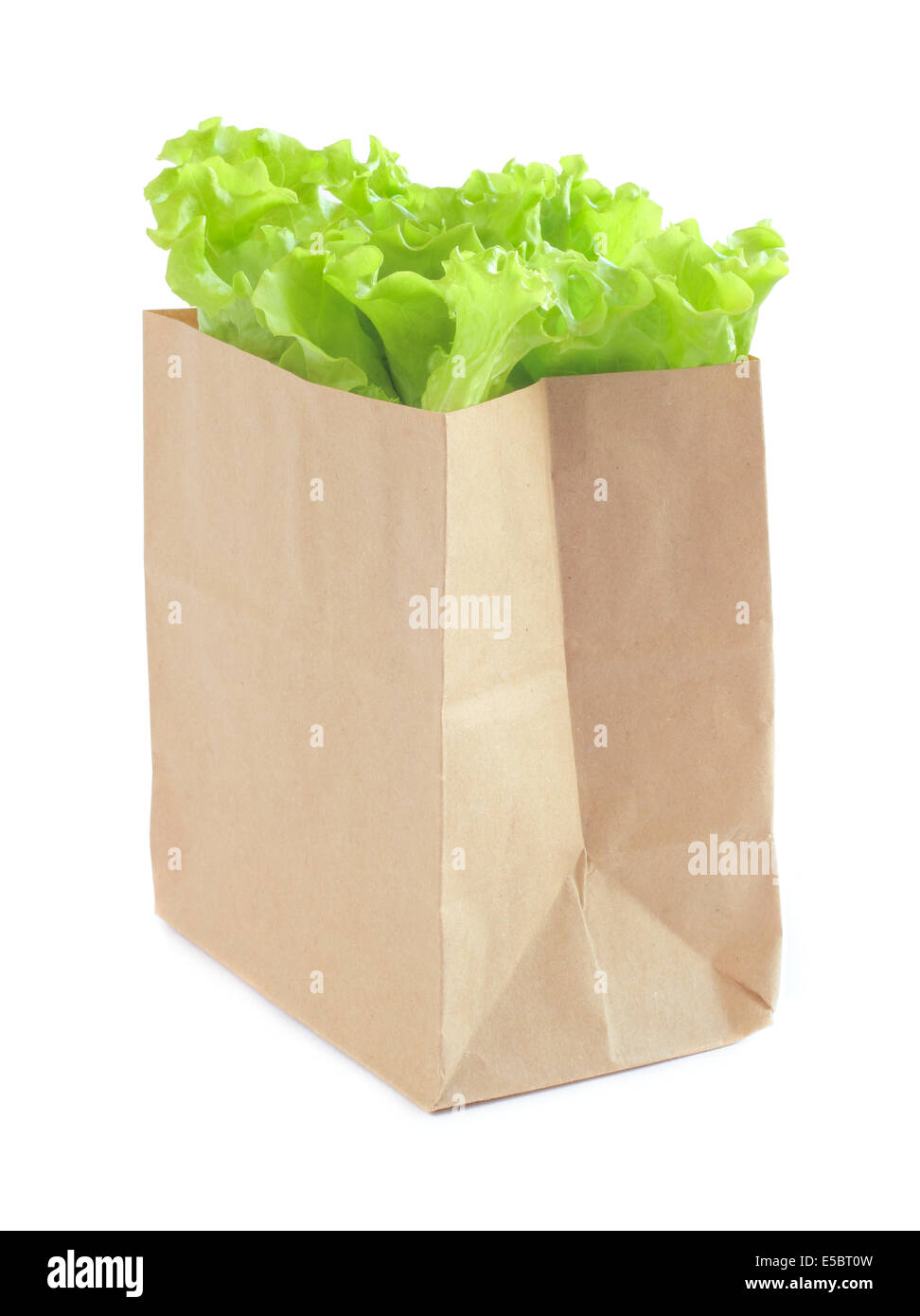 Grocery bag with green lettuce salad isolated on white background Stock Photo
