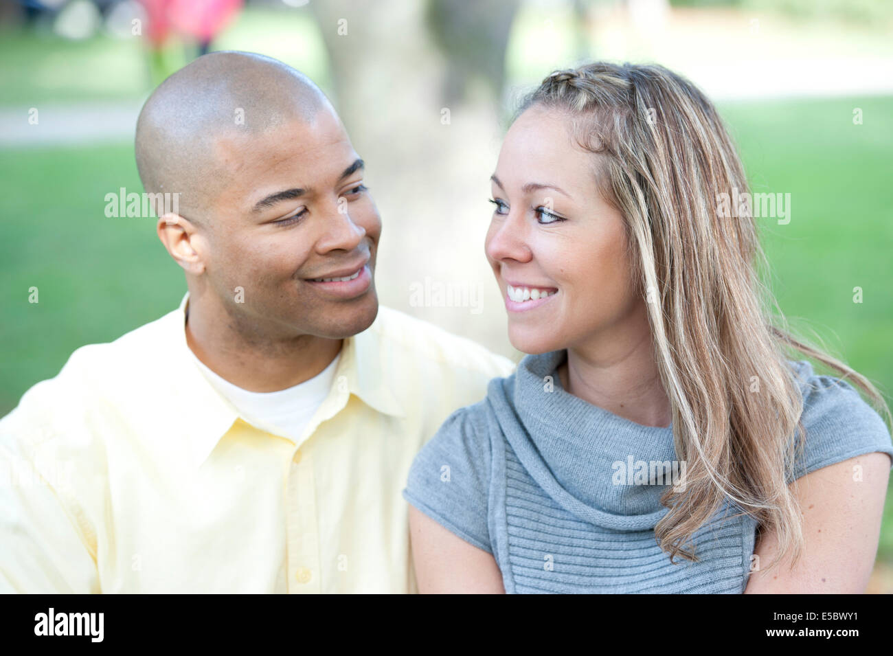 Happy young interracial couple posing together on a sunny day. Stock Photo