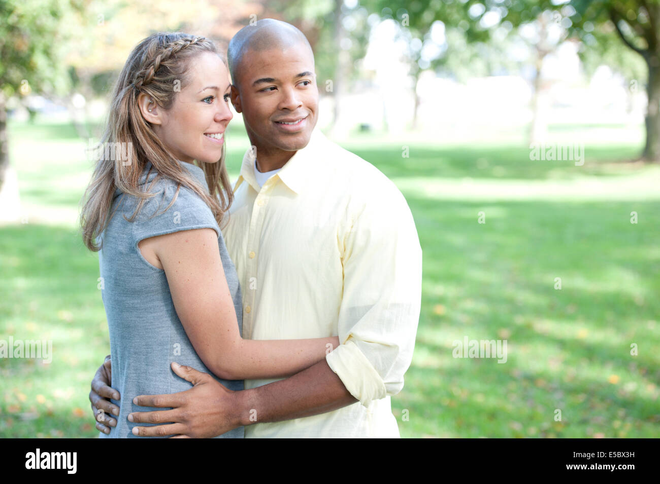A happy young interracial couple looking to the right side Stock Photo