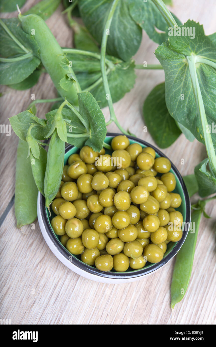 Boiled green peas in a cup, pods and branches Stock Photo