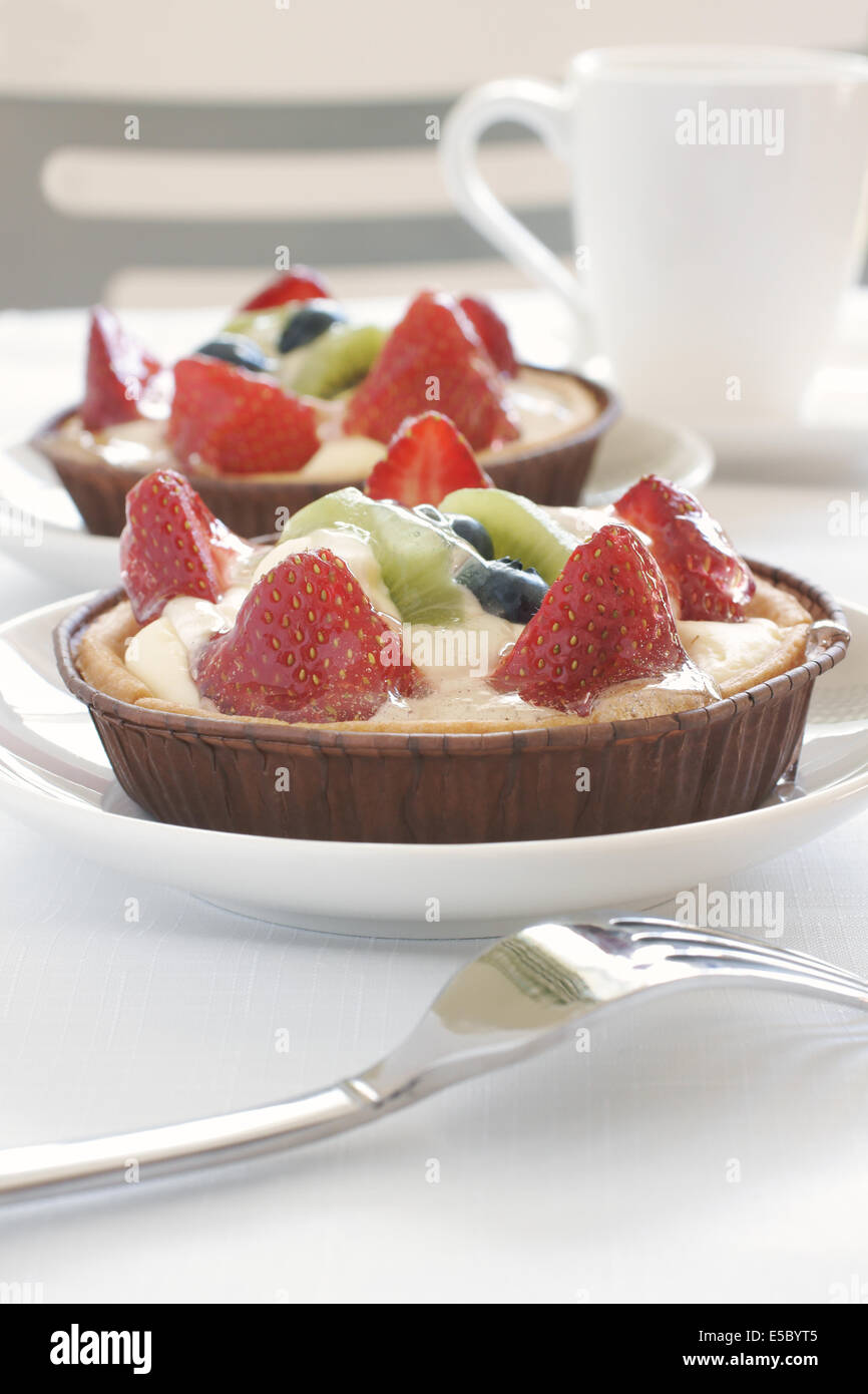 Fruit tarts made with sweet pastry creme patissiere and strawberries, blueberries and kiwi fruit Stock Photo