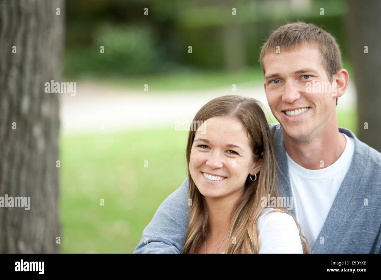 A happy caucasian young couple sitting on a bench at the park Stock ...