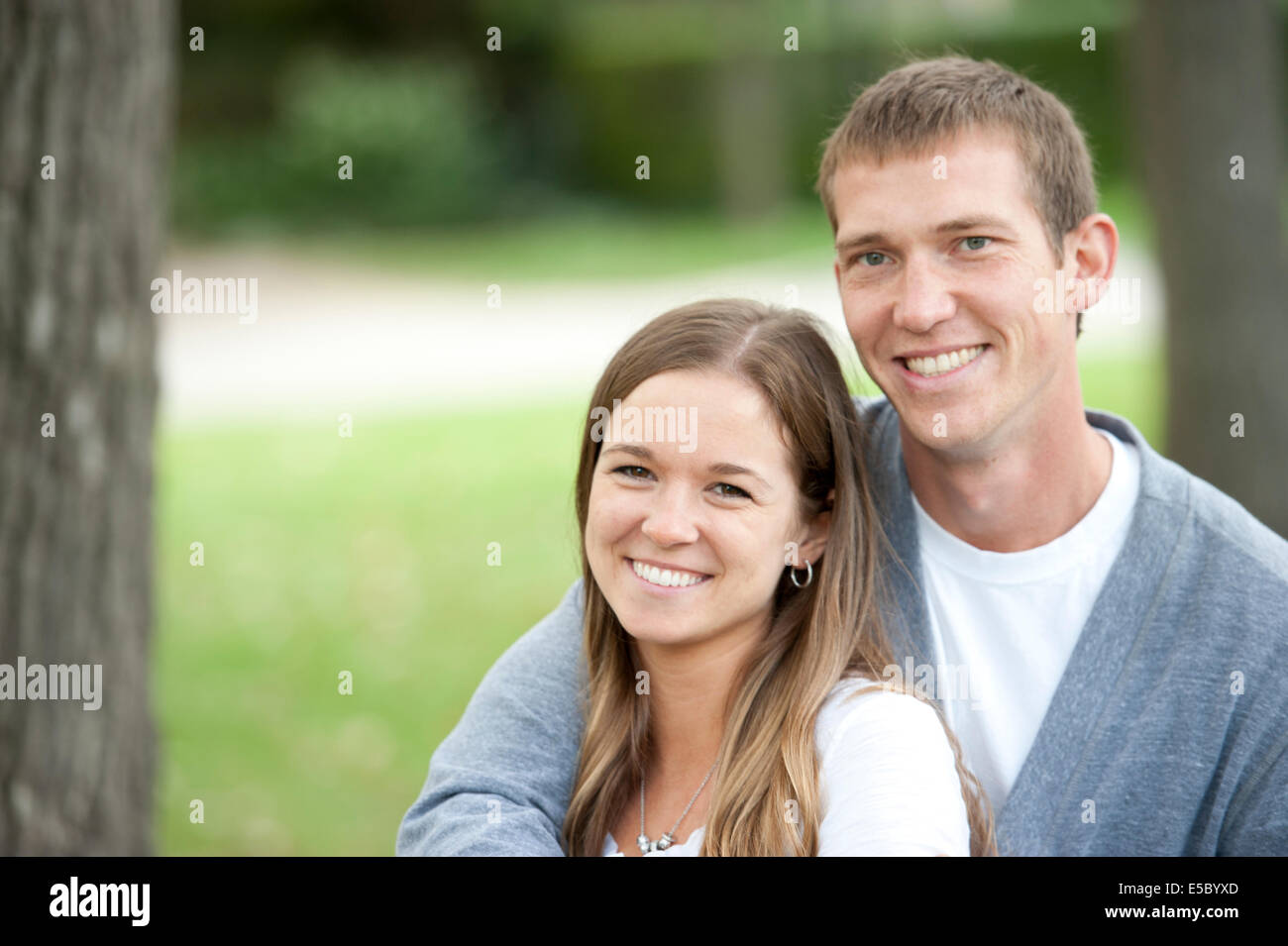 A happy caucasian young couple sitting on a bench at the park Stock ...