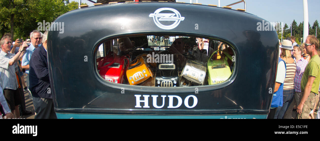 Berlin, Germany. 27th July, 2014. Car handbags of the former racing driver Heidi Hetzer lie in the tail of the classic car, named 'Hudo', which is surrounded by curious onlookers in front of the Olympic stadium in Berlin, Germany, 27 July 2014. Hetzer starts a world trip from Berlin in her Hudson Great Eight classic car, a 1930 model. Photo: Hannibal/dpa/Alamy Live News Stock Photo