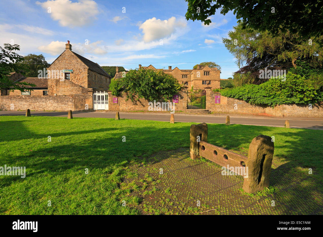 Eyam Hall and stocks on the village green Eyam plague village, Derbyshire, Peak District National Park, England, UK. Stock Photo